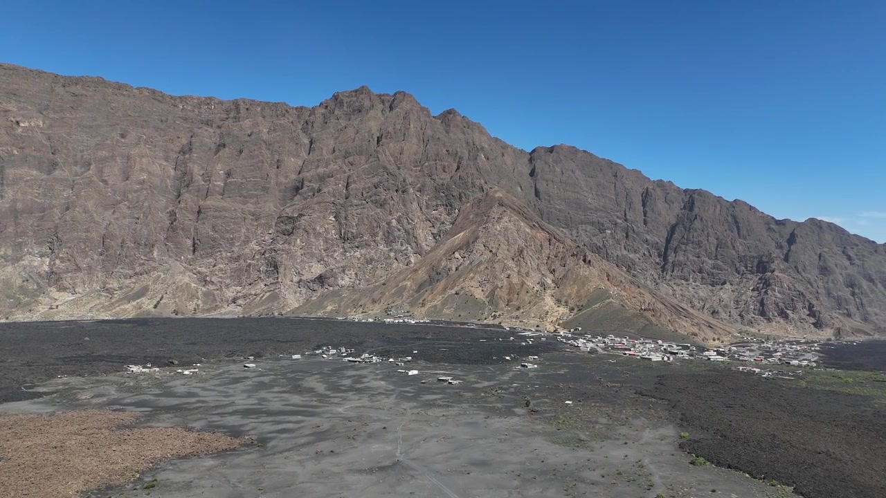 Yeşil Burun Adaları'ndaki etkileyici Fogo Yanardağı'nın havadan panoramik görüntüsü, katılaşmış lav akıntıları ve kraterin dibine yerleşmiş küçük bir yerleşim yeriyle geniş Chã das Caldeiras volkanik manzarasını içeriyor