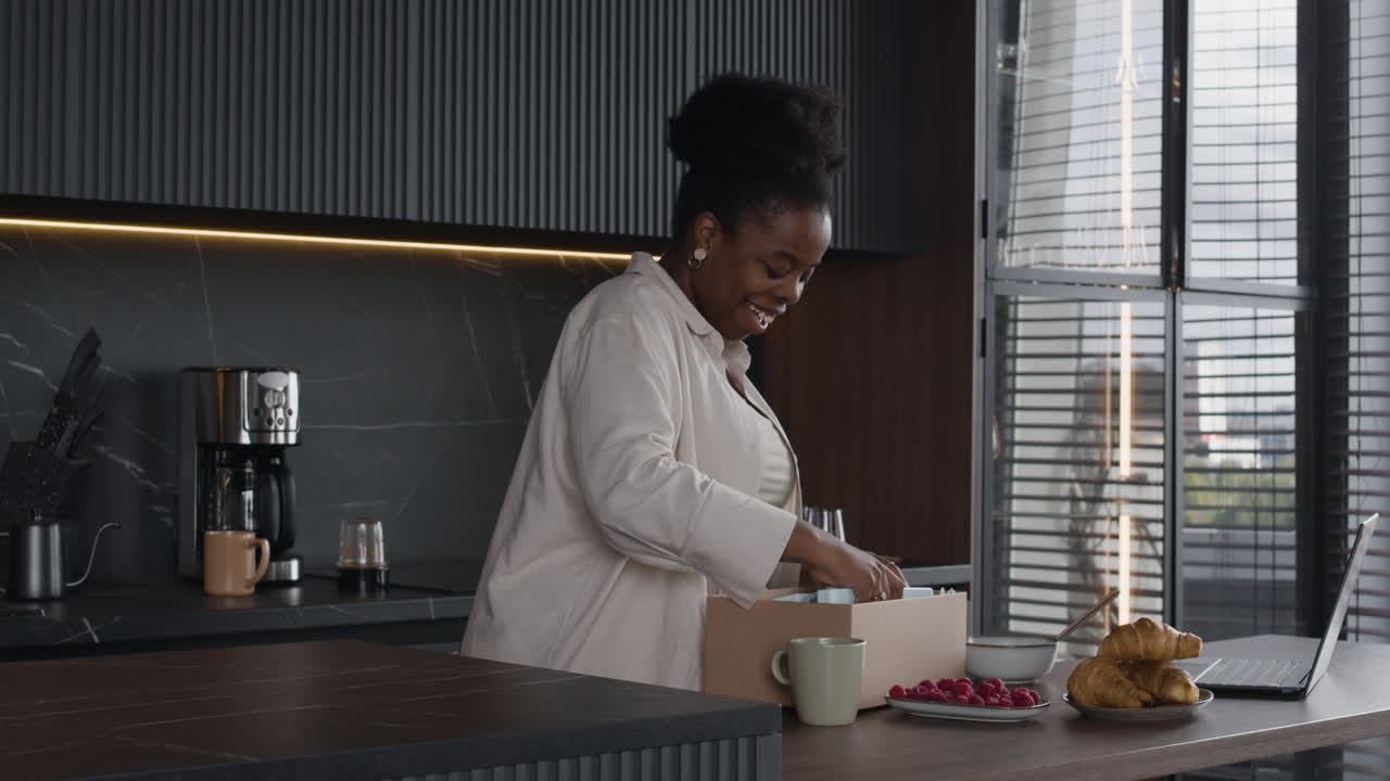 Woman Unboxing a Package in Her Kitchen