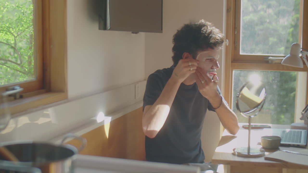 Man Applying Sheet Mask to Face at Home