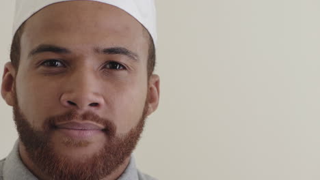 close up portrait happy young muslim man laughing enjoying success cheerful mixed race male wearing kufi hat