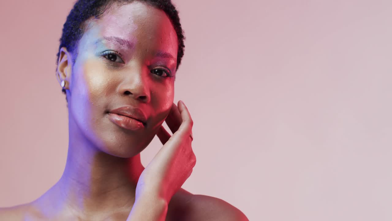 Afroamerikanische Frau mit kurzem dunklem Haar in blauem und rosa Licht mit Textfreiraum, Zeitlupe.