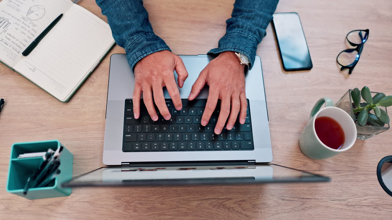 Persona che digita al laptop a una scrivania