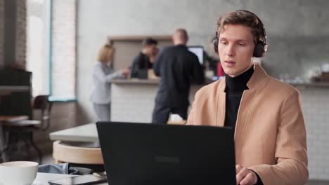 Chico-Joven-Guapo-Estudiando-En-Línea-En-Un-Café