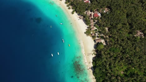 vista aérea de la isla tropical con bungalows en la playa y asombrosas aguas turquesas en indonesia - cámara girando lentamente