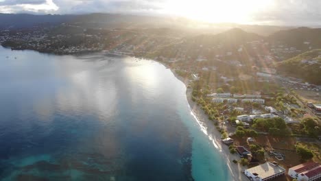 sunset on a tropical beach in grenada, aerial reveal