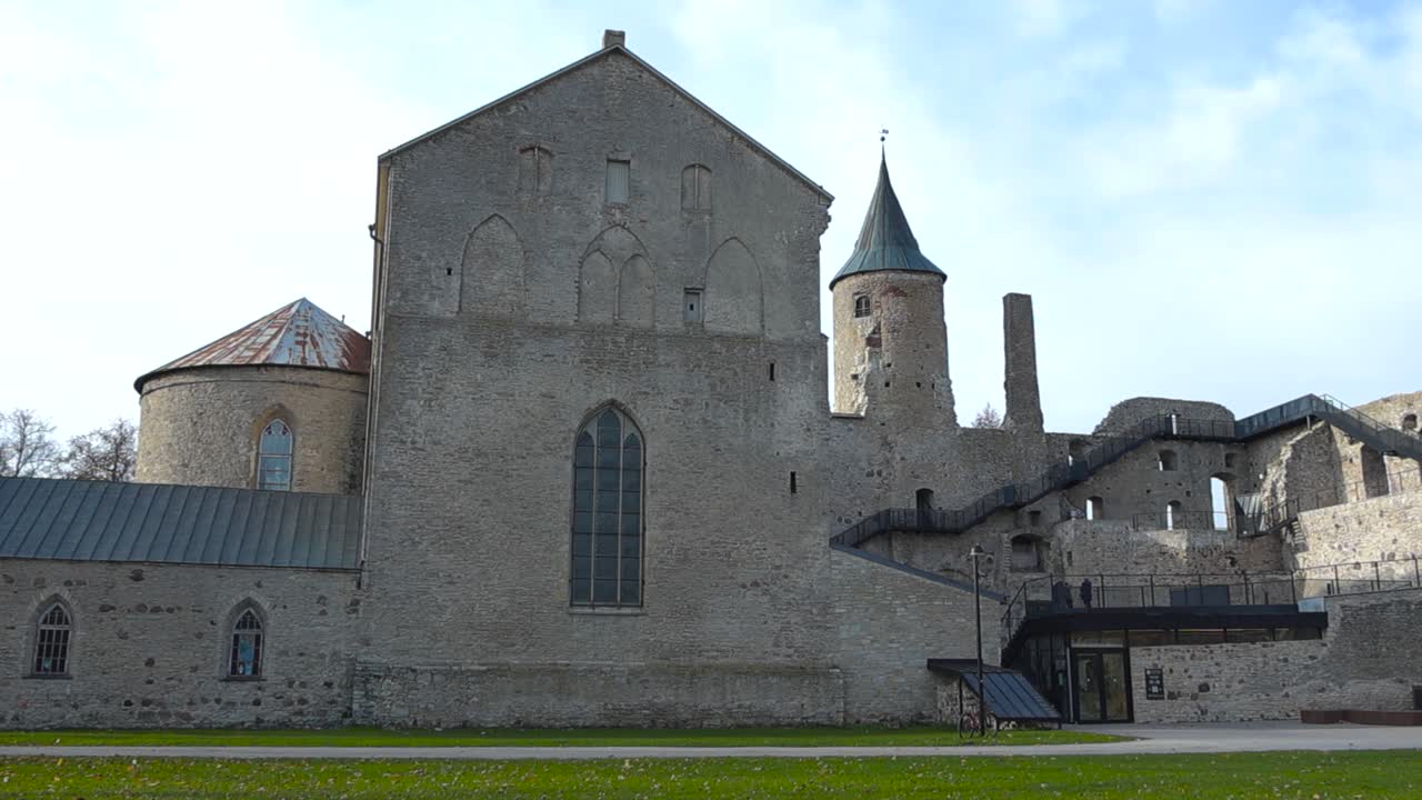 Beautiful footage of Haapsalu castle during late summer or in autumn time while sun is shining on the fortress thick limestone walls and the castle grounds in the foreground. Medieval Hansa city wall.