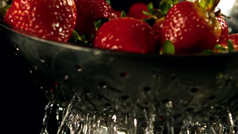 water drops on strawberries in a sieve