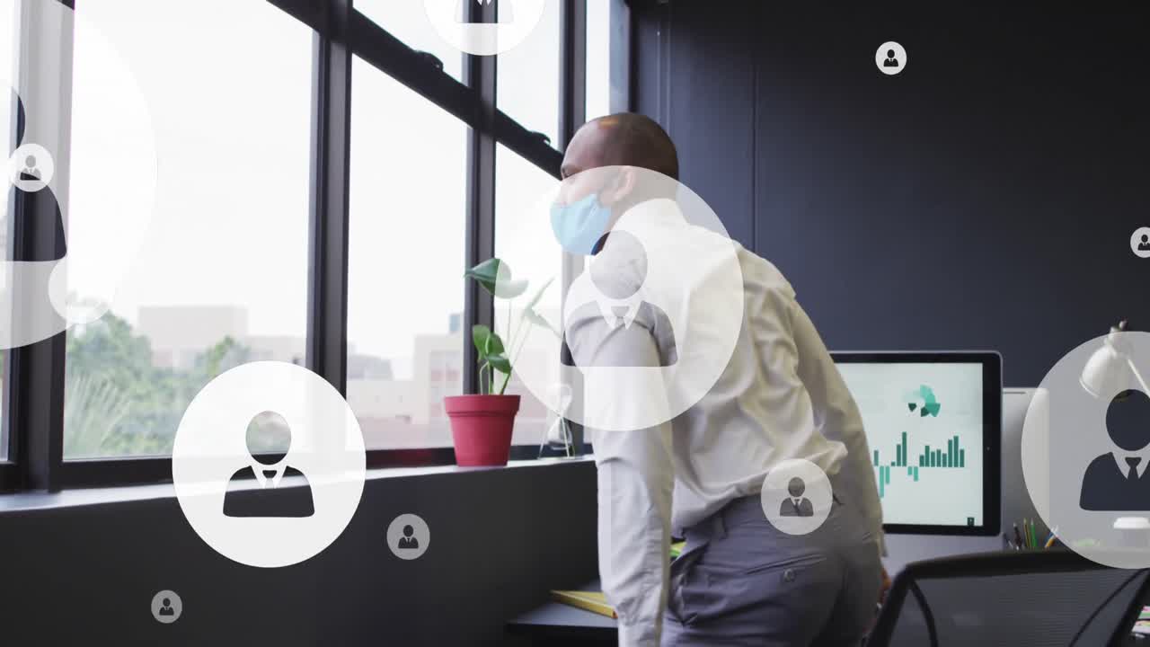 анимация икон профиля, плавающего над двухрасовым мужчиной в маске, глядящим из окна в офисе.
