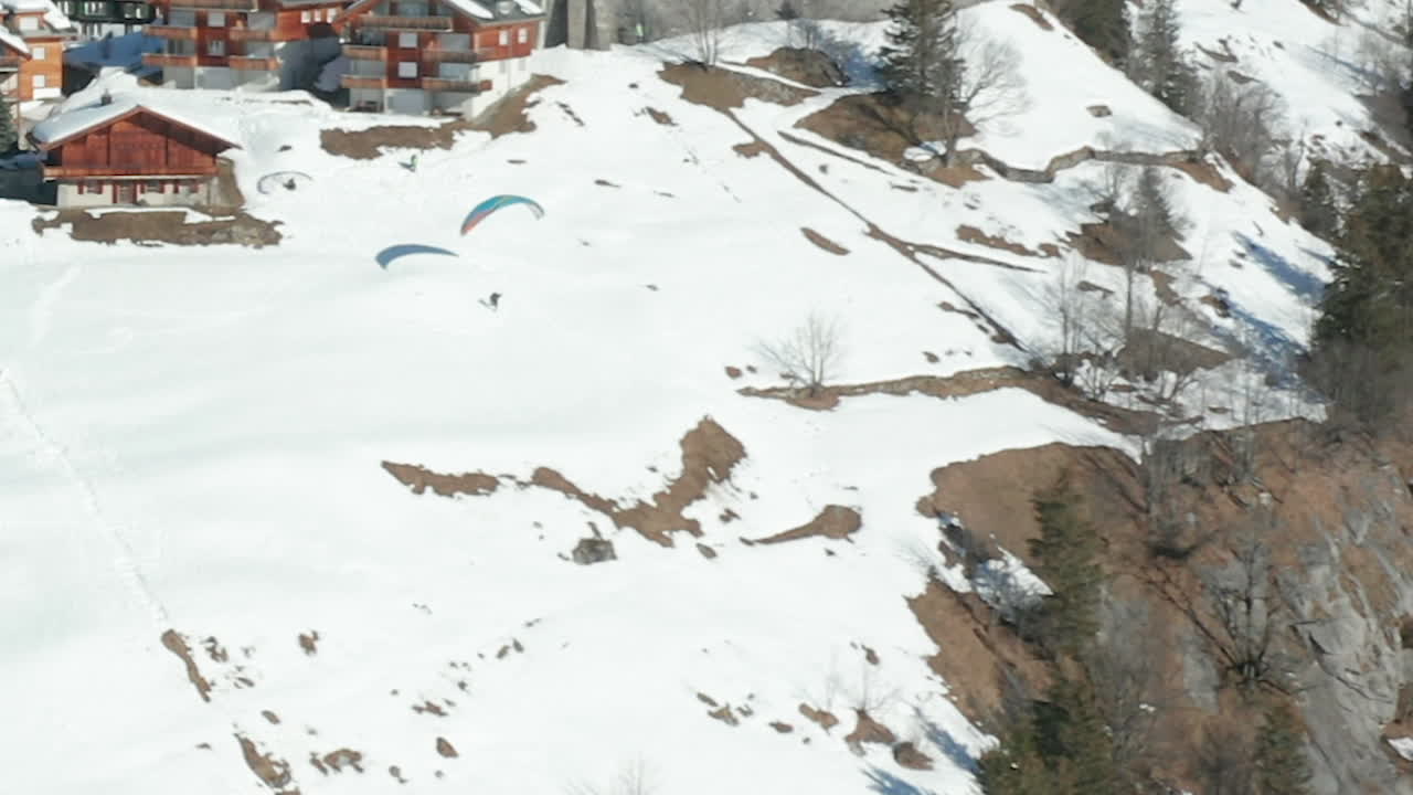 Veduta aerea di un parapendio che si lancia dal bordo di una montagna vicino a una splendida città svizzera - ritaglio 720p.