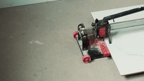 person cutting a tile on a tile cutter