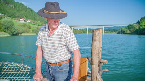 adventurous grandpa rowing a log raft at muta, slovenia in slow motion