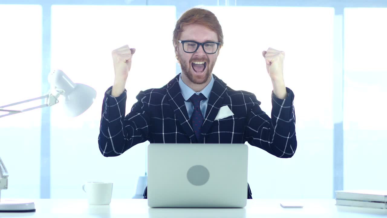 un hombre de negocios pelirrojo celebrando el éxito, la emoción a alto nivel.