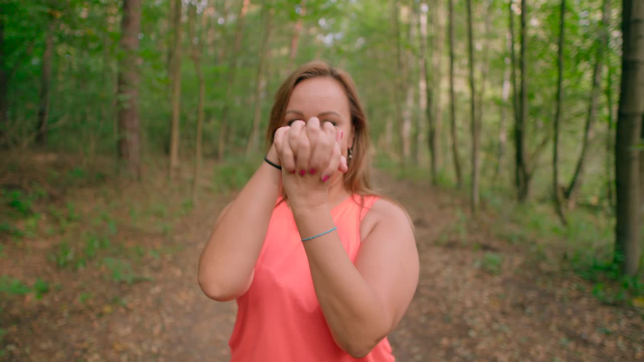 mujer caucásica haciendo ejercicio con las manos estiradas al calentarse al aire libre