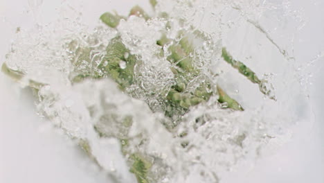 asparagus falling into water in super slow motion