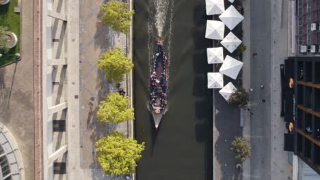 People-enjoy-canoe-ride-through-city-landscape-in-top-down-aerial-view