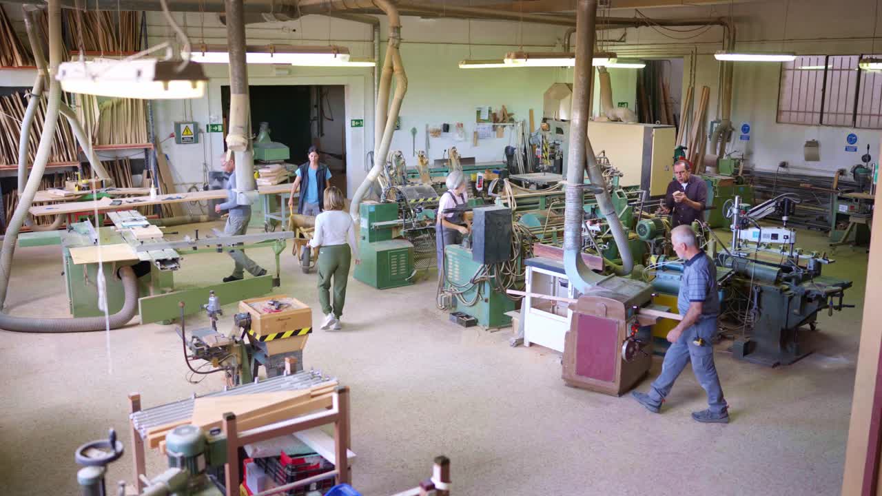 Busy Woodworking Workshop with Multiple Craftsmen Operating Machinery