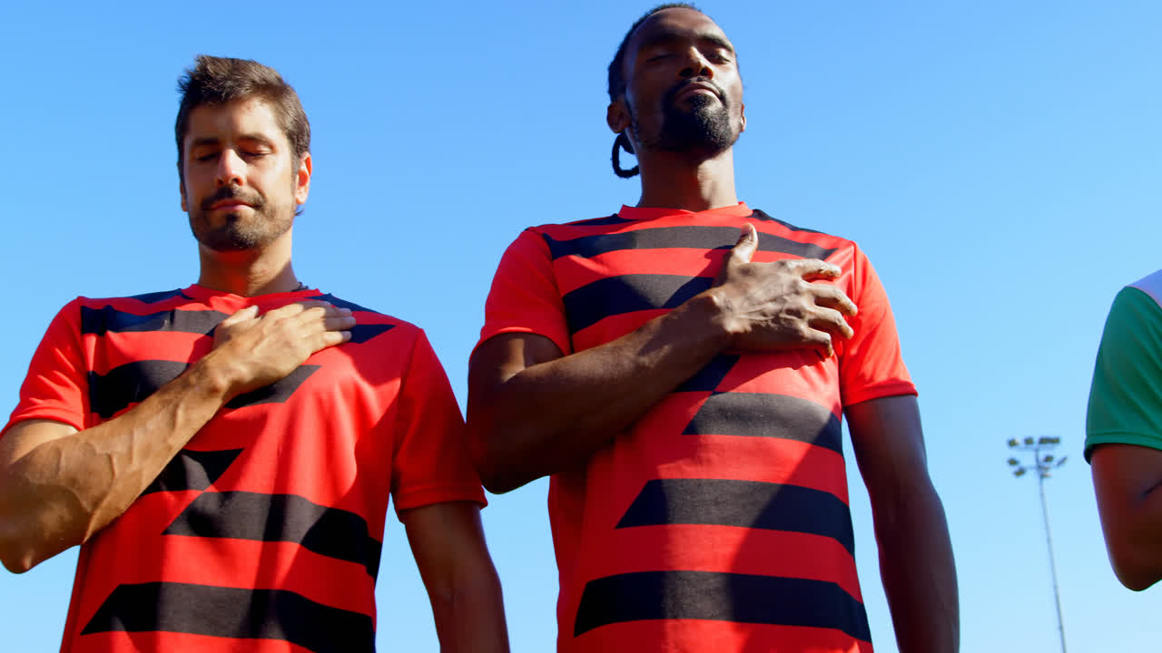 jugadores de fútbol rindiendo homenaje al país antes de comenzar el juego 4k