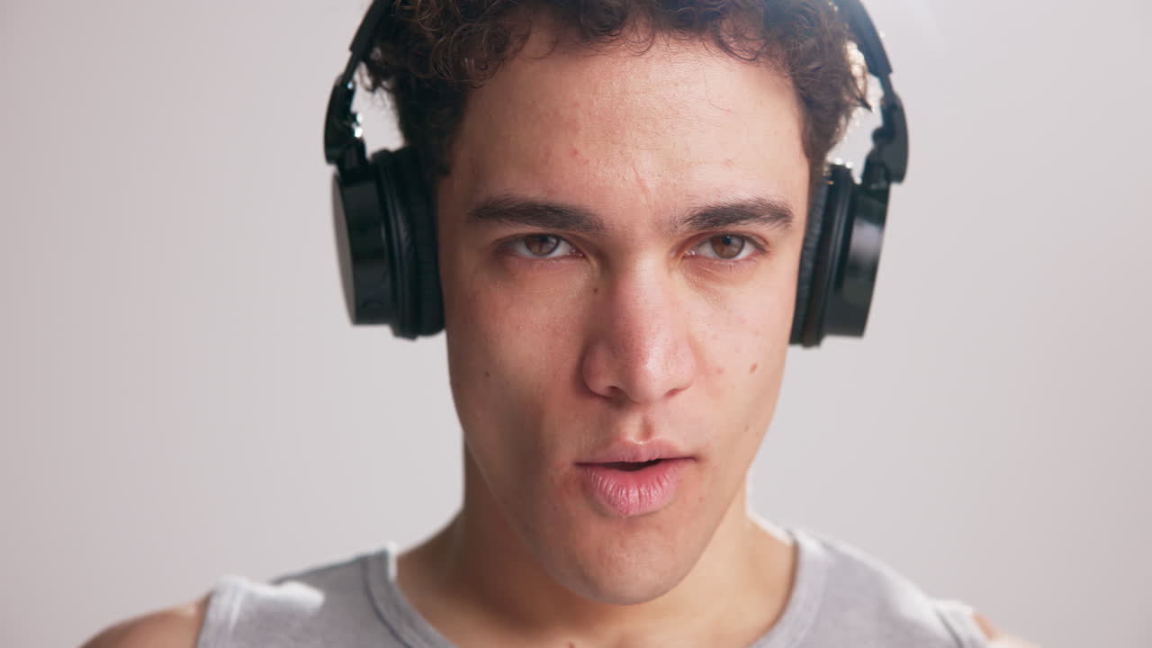 ヘッドホンで音楽を聴きながら言葉を発する若い男性