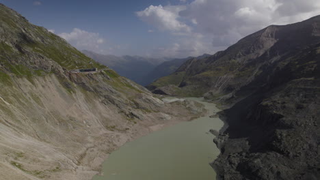 Melting-glacier-lake-stream-from-Pasterze-Glacier-in-High-Tauern-National-Park,-Austria,-Slow-Motion-Aerial-View