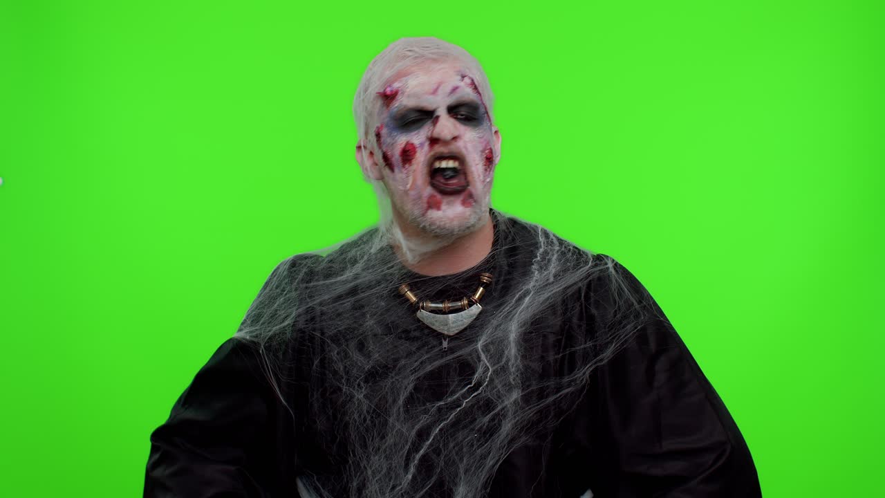 Sinister man scary Halloween zombie making playful silly facial expressions grimacing fooling around