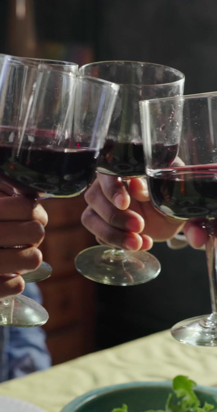 Friends Toasting with Glasses of Red Wine at Dinner