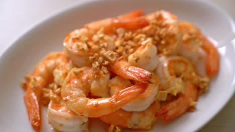 fried shrimps or prawns with garlic on white plate - seafood style