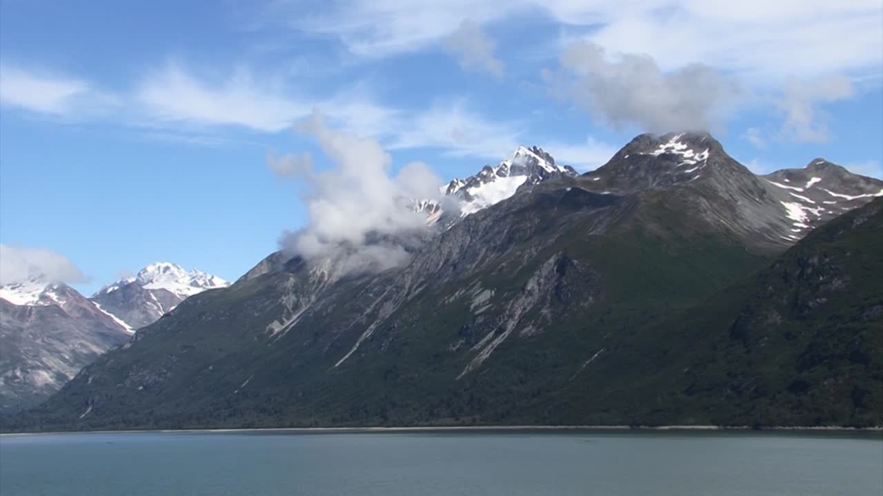 여름 알래스카에서 눈 덮인 산 위에 낮은 구름