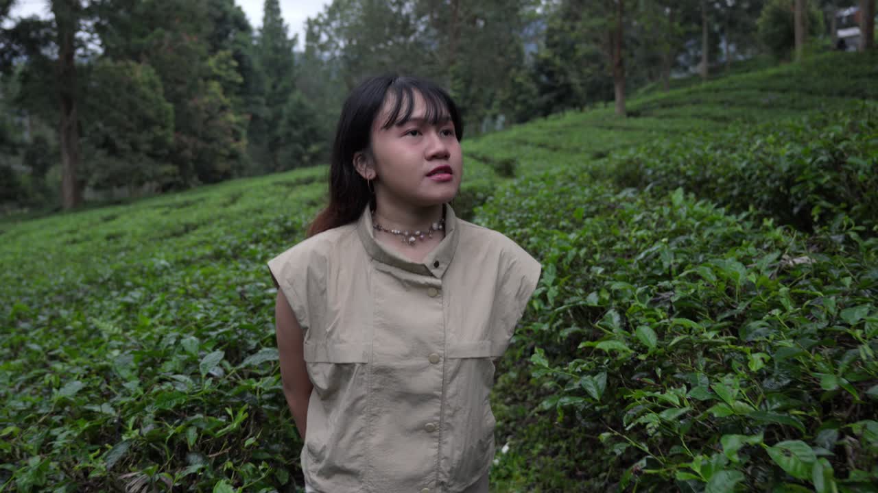 Indigenous girl walking on a tea plantation. Slow motion