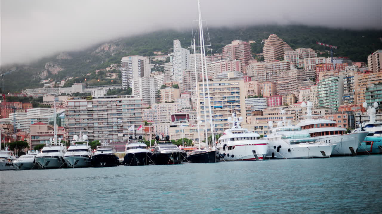View of boats docked in the Monaco Marina with the skyline of the city on the background