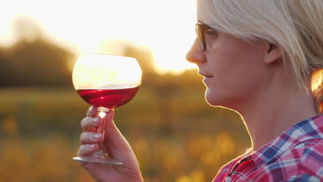 Frau,-Die-Bei-Sonnenuntergang-Rotwein-Verkostet