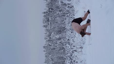 un hombre está haciendo un handstand en el medio de la nieve profunda - tiro vertical