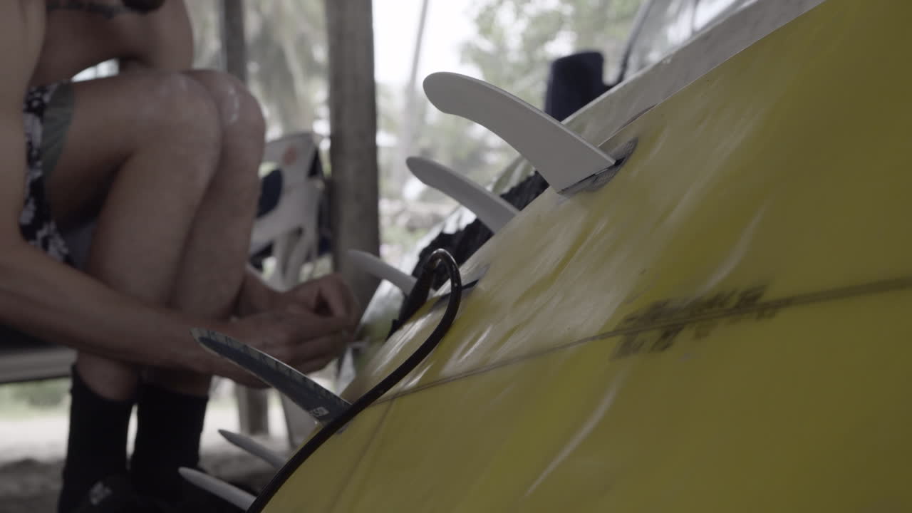 hombre experto reparando tablas de surf rotas con una cuerda