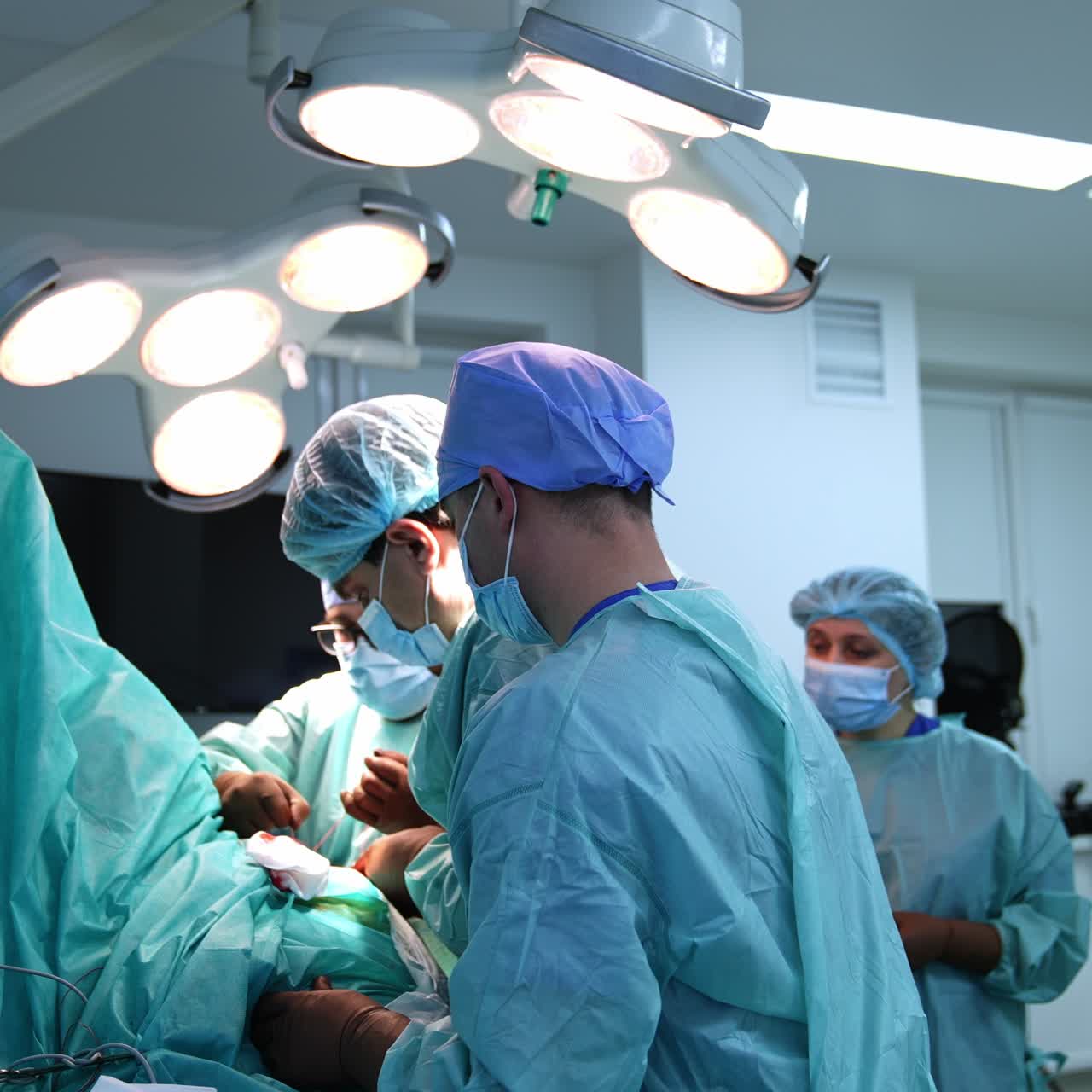 Surgical procedure performed by a professional team of surgeons. Doctors sew the patient at the end of operation