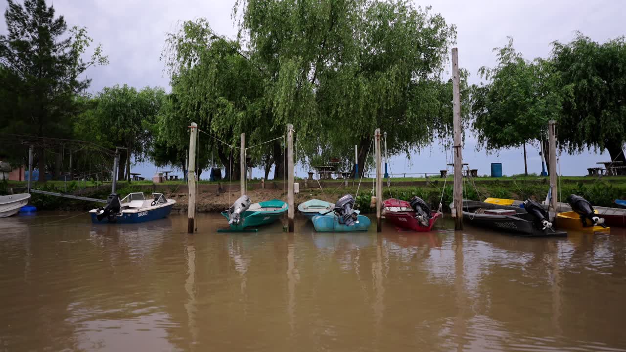 Slightly flooded riverside area with motorboats moored along a riverside dock