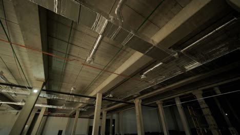 ventilation pipes in silver insulation material hanging from the ceiling inside new building.