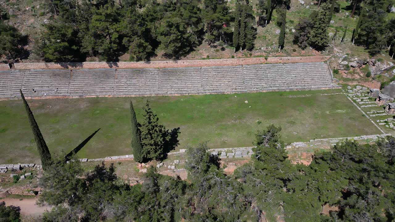 Delphi stadium from above establishing ancient track layout in green mountainous backdrop