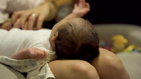 adorable new born baby girl in lap of her mother while changing diapers