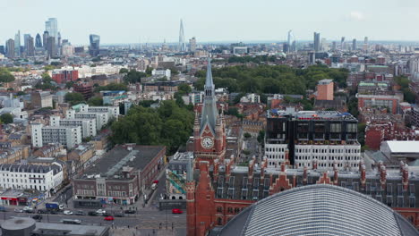 Ascending-shot-of-tower-clock-at-St-Pancras-train-station-in-Camden-borough.-Tilt-down-footage-of-traffic-in-streets.-London,-UK