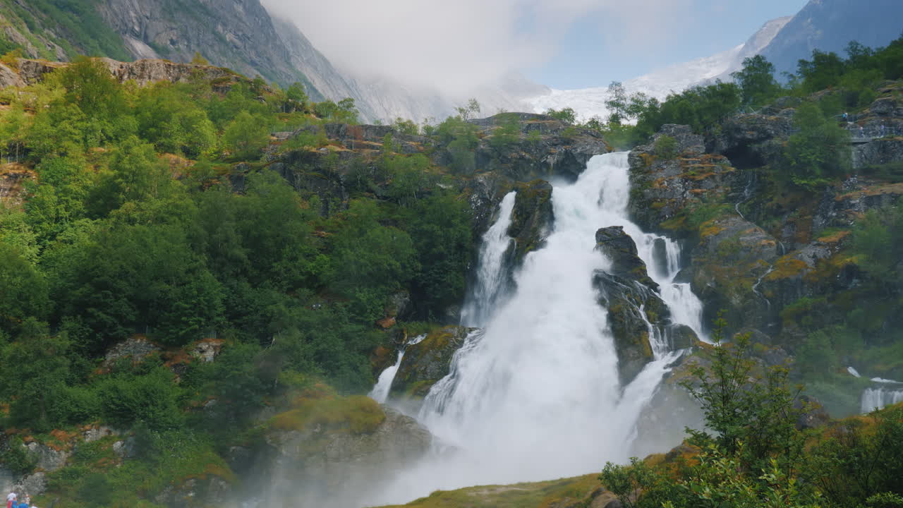 hermosa cascada de las aguas del glaciar en el fondo la montaña con hielo en la parte superior es