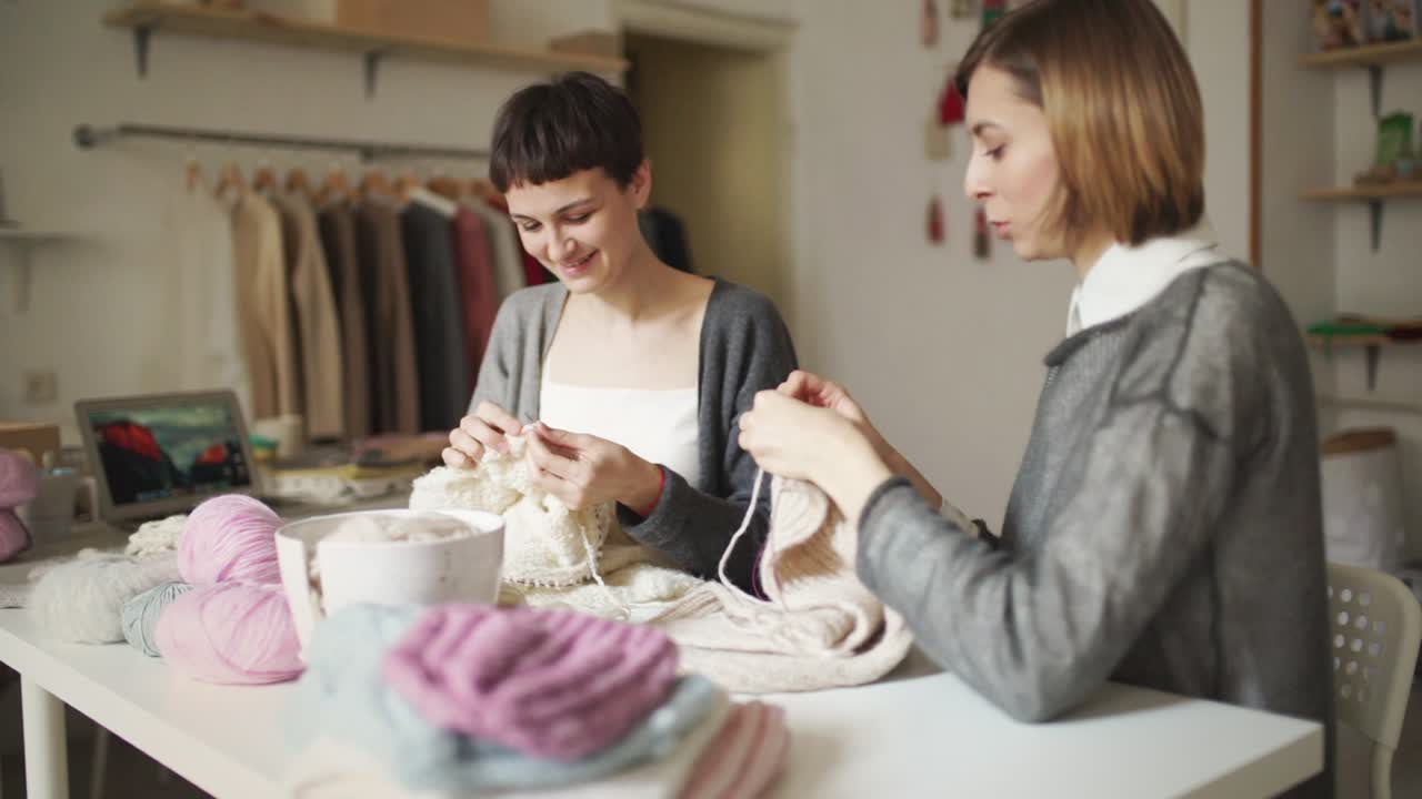 Due donne che lavorano a maglia in un laboratorio tessile. Mani di donna che lavorano a maglia come hobby.