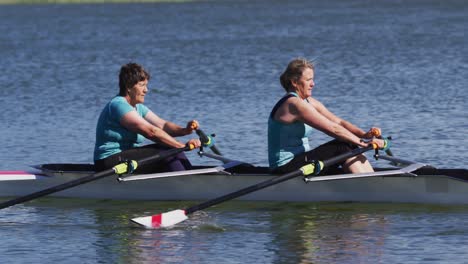 Two-senior-caucasian-women-rowing-boat-on-a-river