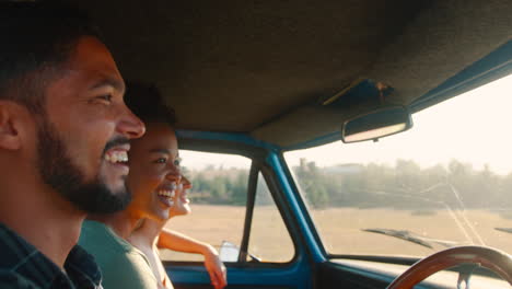 Grupo-De-Amigos-Sonrientes-En-Un-Viaje-Por-Carretera-Conduciendo-En-La-Cabina-De-Una-Camioneta