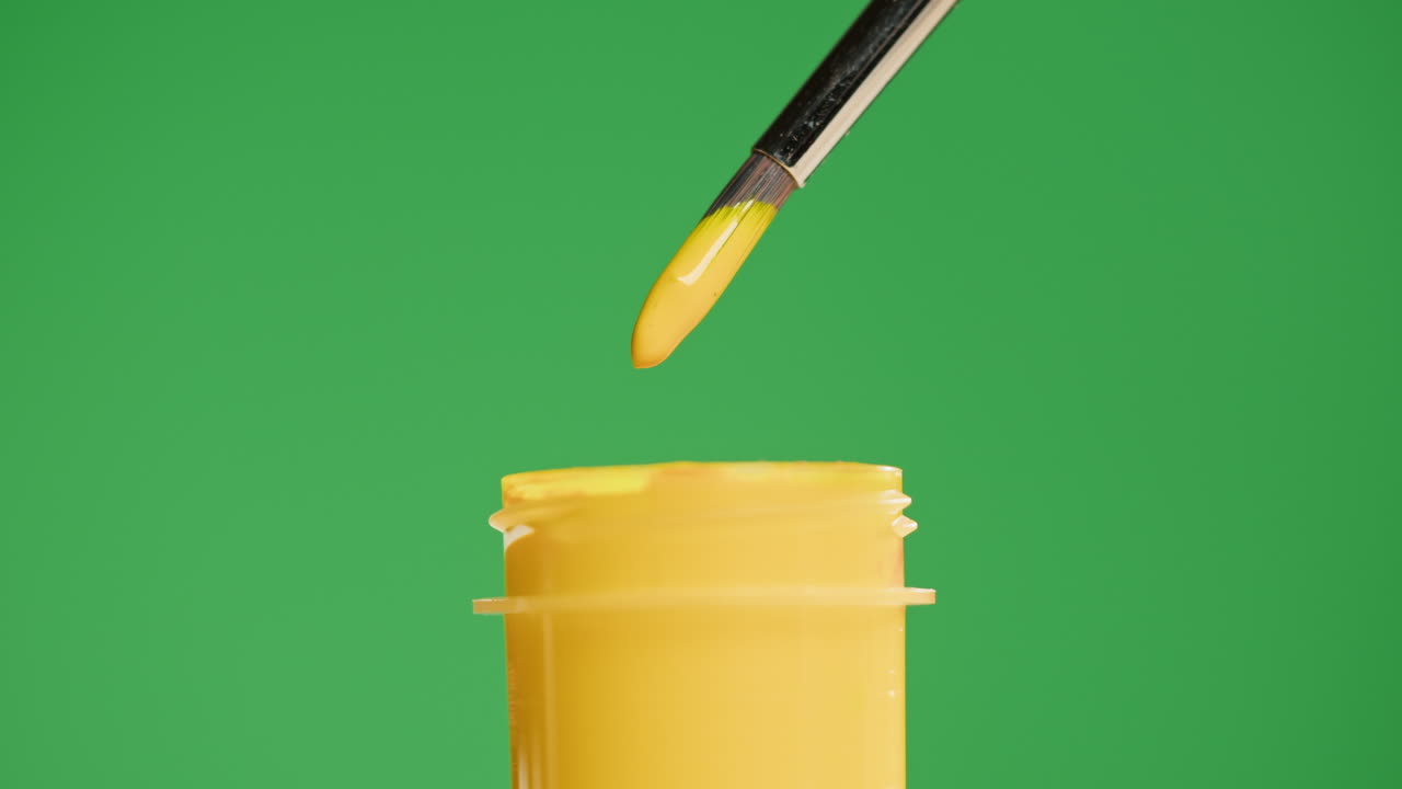 Close-up of Paintbrush Dipping into Yellow Paint