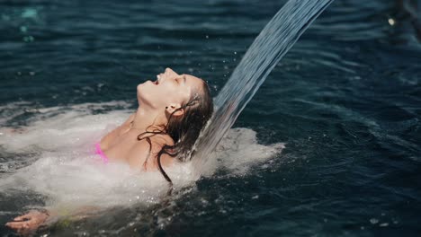 mujer disfrutando de un spray de agua