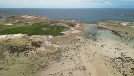 forward tilt aerial view of a beach with a boat on the sand at low tide