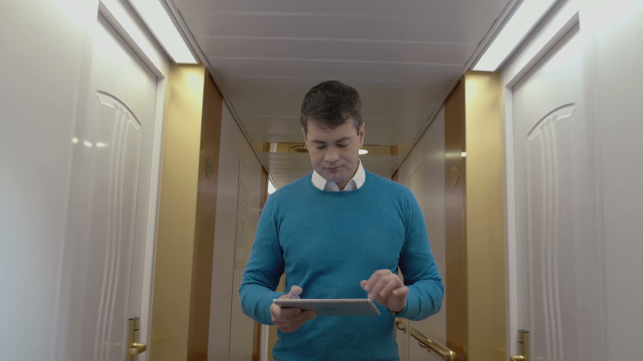 Mand arbejder med tablet på hotelgang