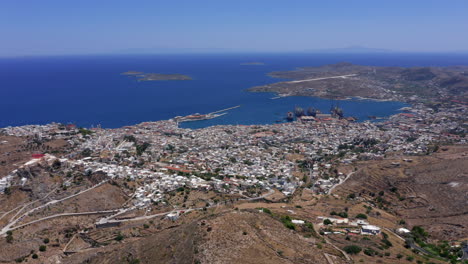 aerial: slow panoramic drone shot of ermoupoli city in syros island, greece on a sunny day