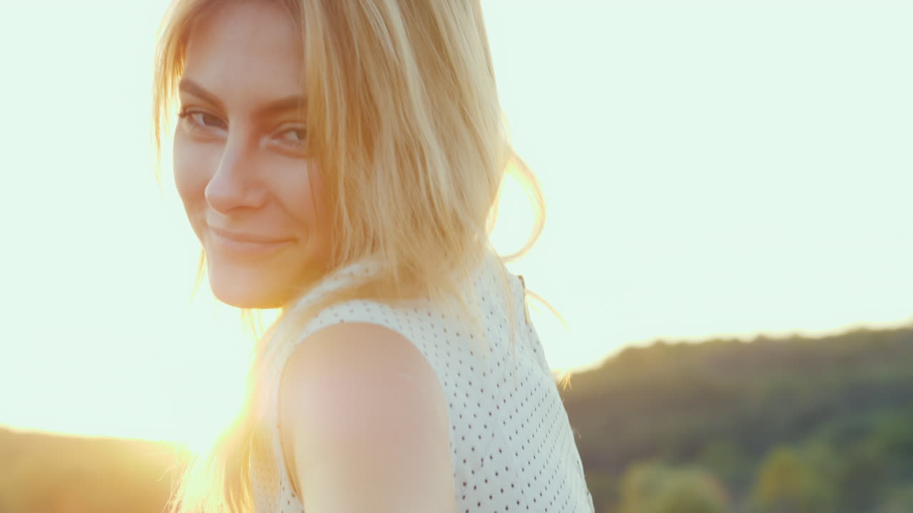 일몰 오렌지 빛에 아름 다운 젊은 여자의 초상화 뒤에 그녀의 머리를 강조