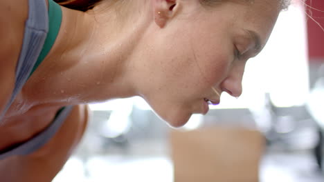 close-up of a young caucasian woman exercising intensely at the gym