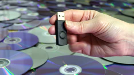 woman with usb memory stick near cd and dvd discs.new and old technology concept